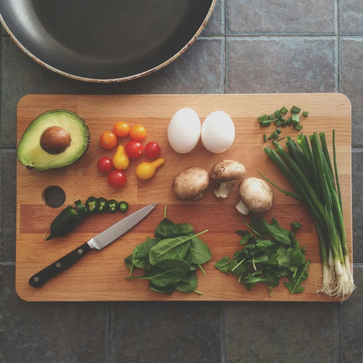 Fresh vegetables, eggs and greens laid out on a wooden board